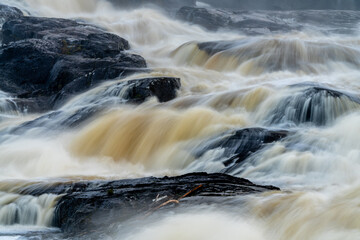 Rough water in the river crashing against the rocks