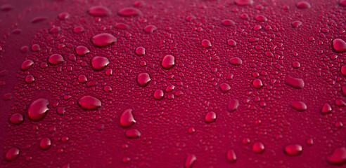 Drops of water on red surface. Macro photo, drop, shadow