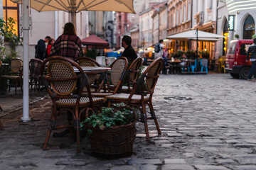 Table with chairs on the streets of a beautiful tourist city. Cozy cafe with a street terrace at...