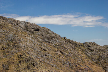 Beautiful Summer scenery: yellow and brown mountains under the blue cloudy sky. Central Asian mountain background. 