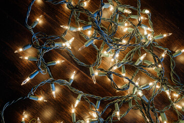 White Holiday lights set against an old vintage dark wood barn floor