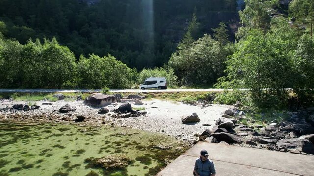 Tourist on the Concrete Fjord Pier and His RV Camper Van