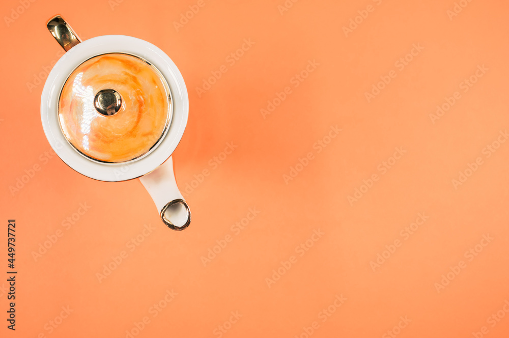 Sticker Top view of an orange covered ceramic teapot on an orange isolated background with free space