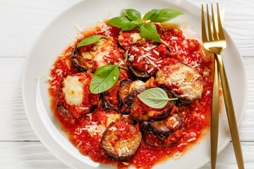 eggplant parmigiana on a white plate, top view