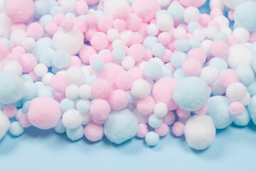 White, pink and blue soft pompons as a background.