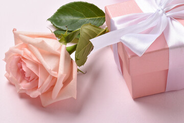 One pink rose and a gift box.