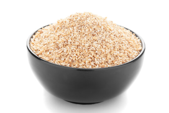 Close-Up of organic broken wheat (dalia or daliya ) roasted  in black ceramic bowl over white background