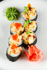 tempura sushi roll with salmon and tobiko caviar on a white plate