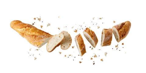 Fotobehang Brood Cutting fresh baked loaf wheat baguette bread  with crumbs and seeds flying isolated on white