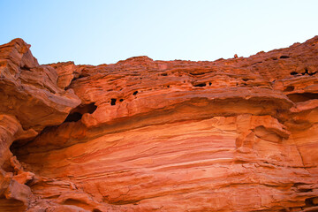 red rocks of a desert canyon against a blue sky view from the bottom up