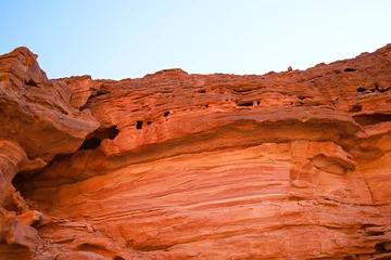 Foto op Plexiglas red rocks of a desert canyon against a blue sky view from the bottom up © Roman