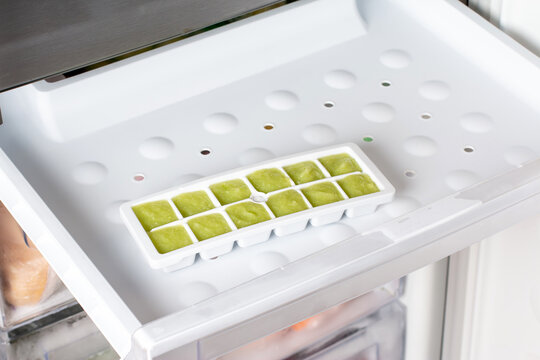 Frozen zucchini puree in ice cubes tray in refrigerator. Frozen Food