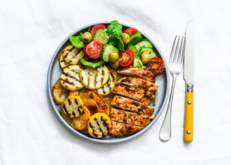 Barbecue plate - chicken breast, yellow zucchini, grilled potatoes and fresh vegetable salad with...