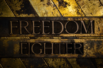 Freedom Fighter text message on grunge textured copper and gold background