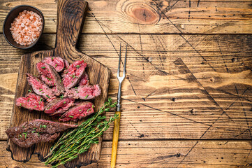 Sliced grilled machete skirt meat beef steak on a wooden cutting board. wooden background. Top view. Copy space