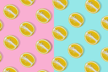 Trendy summer idea with yellow lemon halves on bright pink and blue background.