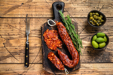 Spanish traditional tapas Sliced chorizo salami, chorizo sausage. wooden background. Top view - obrazy, fototapety, plakaty