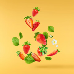 Fresh raw ripe strawberry with green leaves falling in the air, food levitation