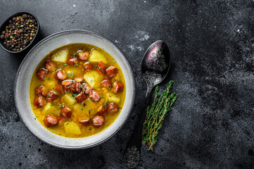 German Split pea soup with smoked sausages and meat. Black background. Top view. Copy space