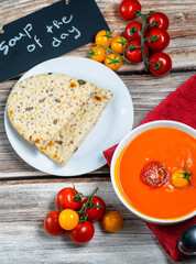 Fresh tomato soup served with bread and fresh cherry tomatoes