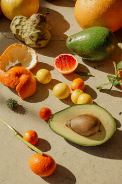 Assortment of tropical fruits like avocados on a concrete background