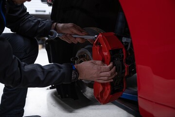 Man car mechanic repairing car brakes in car service