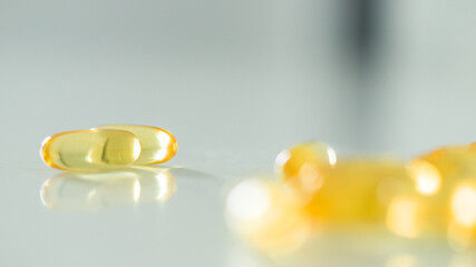 Fototapeta na wymiar Omega 3. Vitamin drops pill capsule. Shining golden drop of essence. Nutrition skin care design for cosmetic procedures.