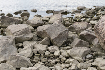 Stone seashore. Stones on the background of water