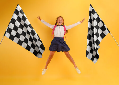 Young girl student jumps high happy for the promotion and reaches the flag. Yellow background