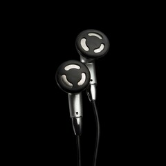 Headphones for mobile devices on a black background, close-up.