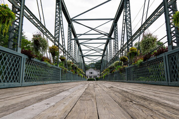 Iron bridge decorated with flowers.  Wooden boards. 