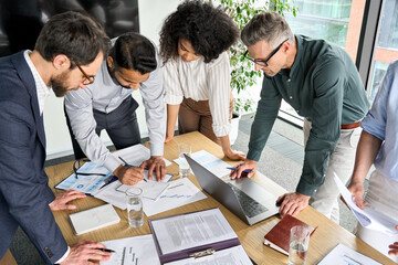 Diverse international executive business people group brainstorming at boardroom meeting table....