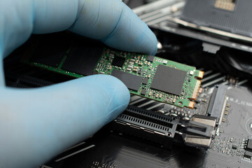 Technician connects an ssd hard drive to a motherboard
