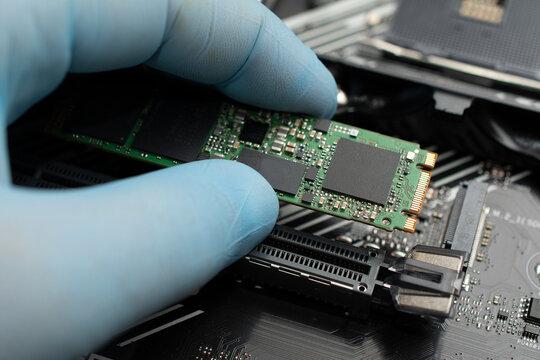 Technician connects an ssd hard drive to a motherboard