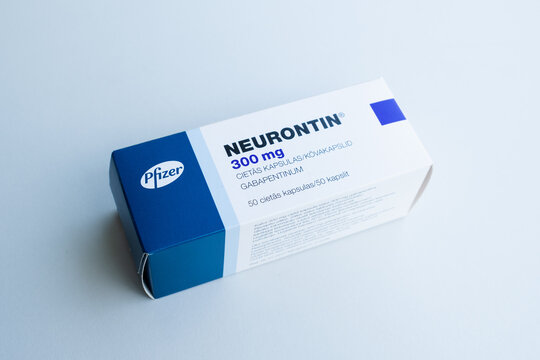 Tallinn, Estonia - July 16, 2021: Hand holding Neurontin capsules by Pfizer to relieve pain caused by nerve damage (neuropathic pain). Pharmacy and medicine concept.