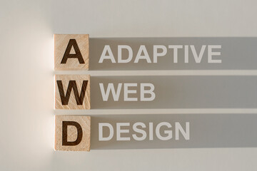 Wooden cubes with the word AWD - Adaptive Web Design, with a falling shadow on a gray background.