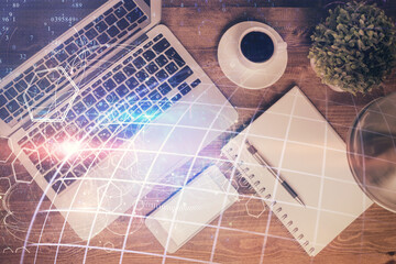 Double exposure of map hologram drawing over study table background with computer. Concept of international network. Top view.