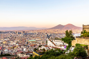 Obraz premium Napoli, Italy - July 11, 2021: Bay of Napoli and Vesuvius volcano in background at sunset in a summer day in Italy, Campania
