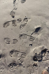 Huellas en la arena, fondo con textura y figura. Vertical