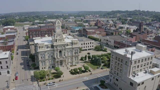A forward aerial establishing shot of the Muskingum County Courthouse in downtown Zanesville, Ohio.  	