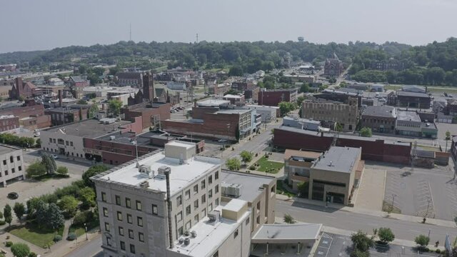 A forward aerial establishing shot of the business district in downtown Zanesville, Ohio.  	
