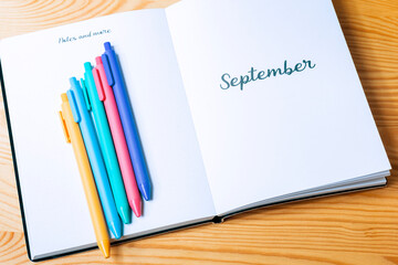 Bolígrafos de colores encima de una agenda.