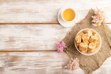 Traditional turkish delight (rahat lokum) with cup of green tea on a white wooden background. top view, copy space.
