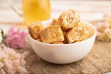 Traditional turkish delight (rahat lokum) with glass of green tea on a white wooden background. side view, close up.
