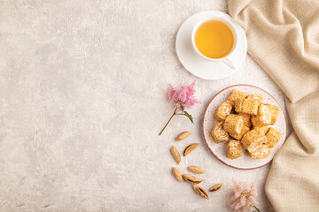 Traditional turkish delight (rahat lokum) with cup of green tea on a gray concrete background, top view, copy space.