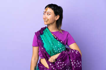 Indian woman isolated on purple background looking side