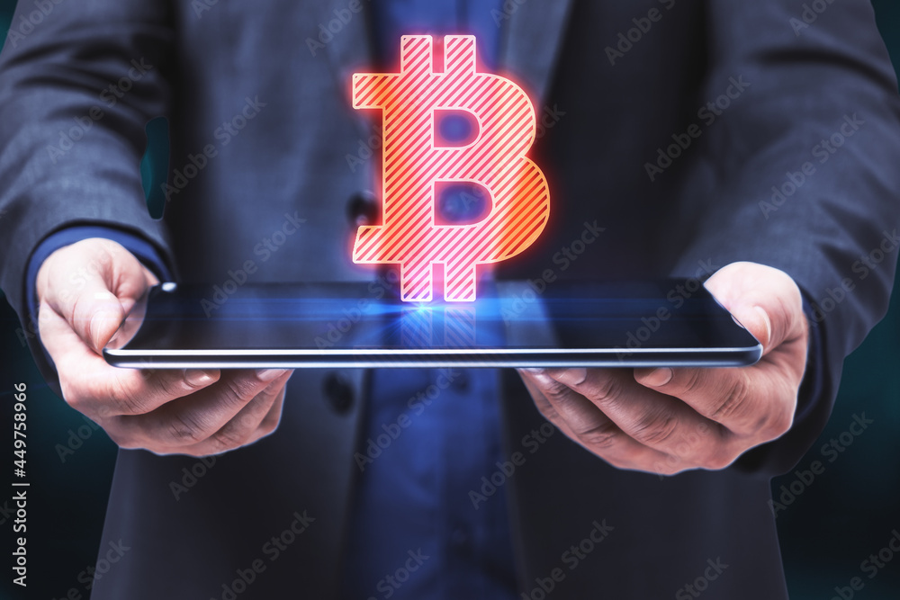 Poster close up of male hands holding tablet with abstract glowing bitcoin sign on blue background. cryptoc
