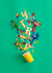 cup filled with colorful party objects
top view, ready for fun 
