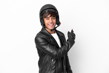 Young man with a motorcycle helmet isolated on white background pointing back