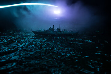 Silhouettes of a crowd standing at blurred military war ship on foggy background. Selective focus....